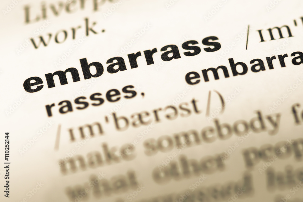 Close up of old English dictionary page with word embarrass Close up of old English dictionary page with word embarrass