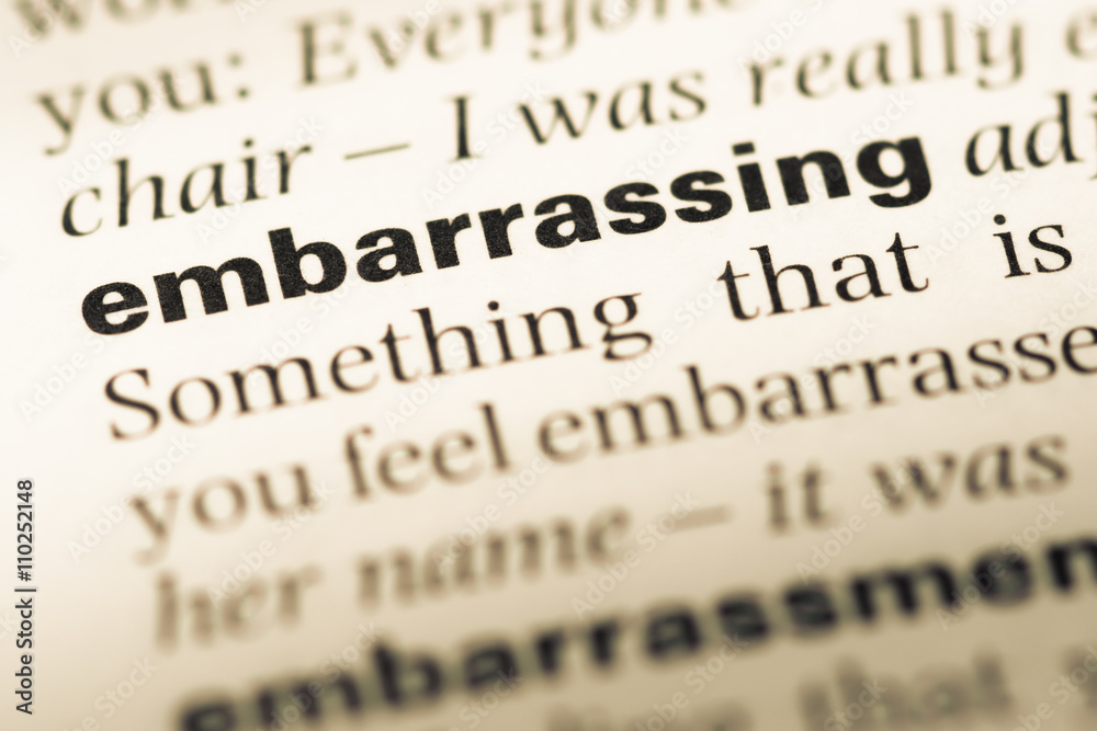 Close up of old English dictionary page with word embarrassing Close up of old English dictionary page with word embarrassing