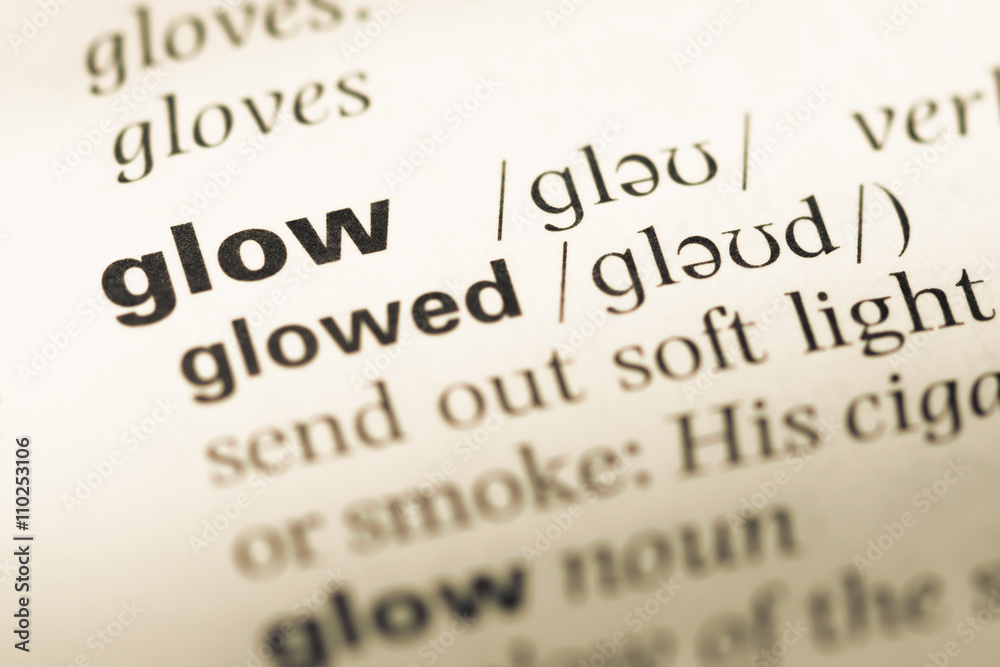 Close up of old English dictionary page with word glow