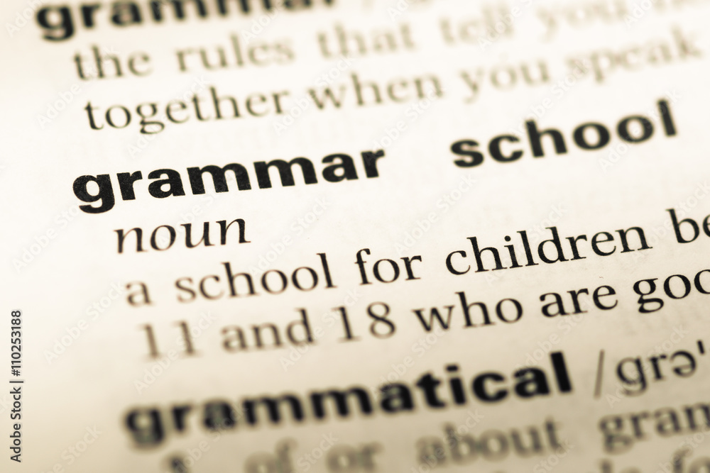 Obraz premium Close up of old English dictionary page with word grammar school