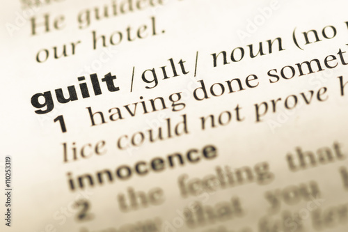 Close up of old English dictionary page with word guilt