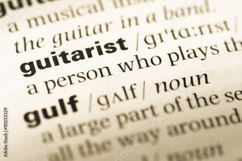 Close up of old English dictionary page with word guitarist