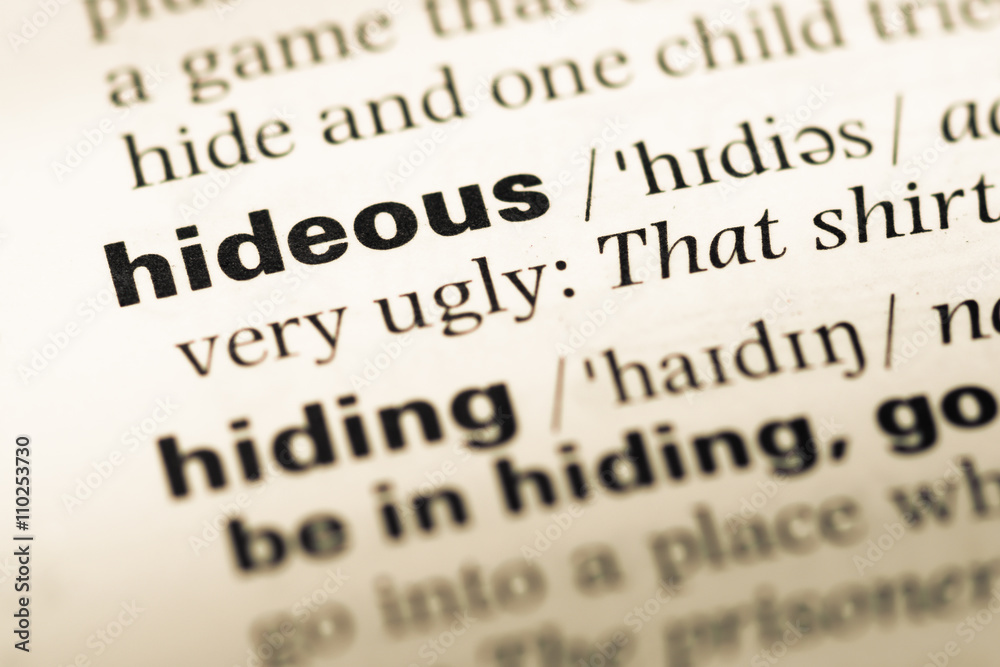 Close up of old English dictionary page with word hideous Close up of old English dictionary page with word hideous