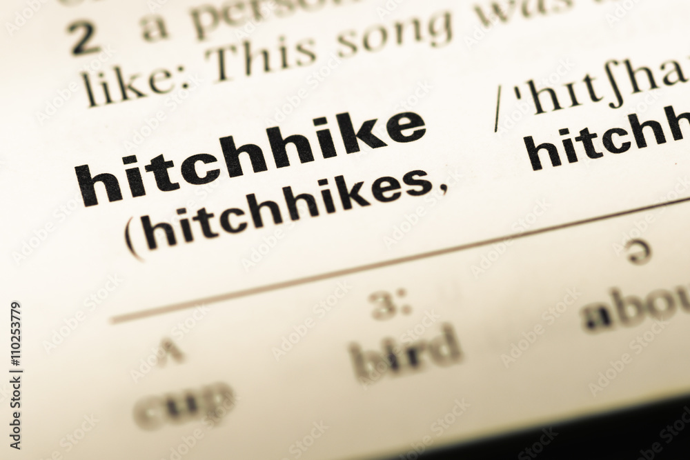 Close up of old English dictionary page with word hitchhike Close up of old English dictionary page with word hitchhike