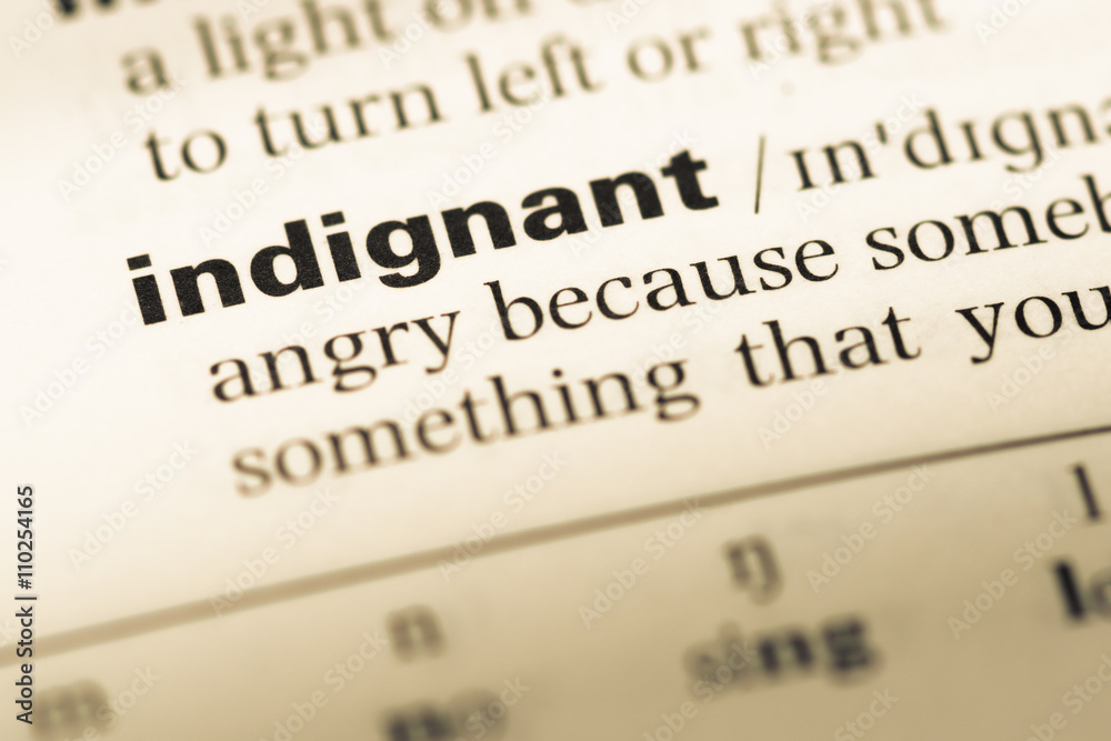 Close up of old English dictionary page with word indignant Close up of old English dictionary page with word indignant