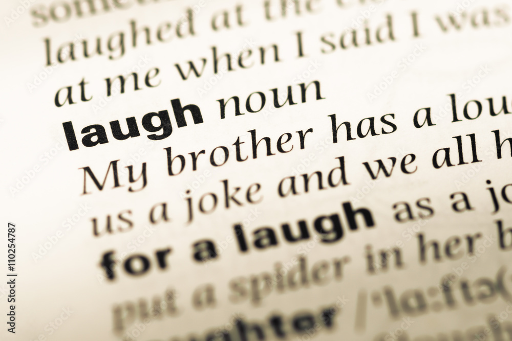 Close up of old English dictionary page with word laugh Close up of old English dictionary page with word laugh