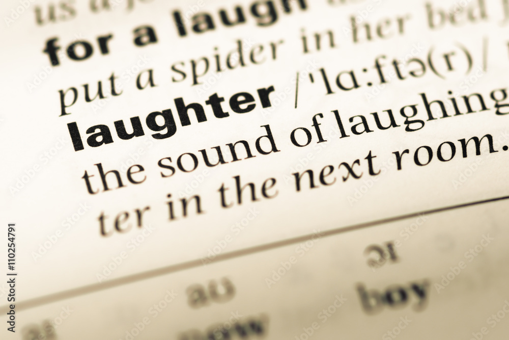 Close up of old English dictionary page with word laughter Close up of old English dictionary page with word laughter