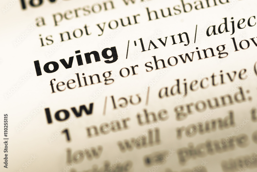 Close up of old English dictionary page with word loving Close up of old English dictionary page with word loving