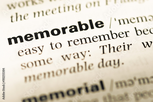 Close up of old English dictionary page with word memorable