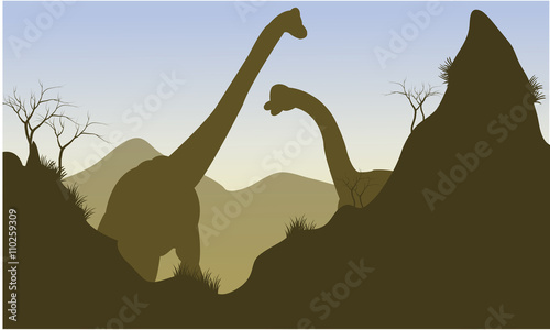 Silhouette of brachiosaurus behind the cliff
