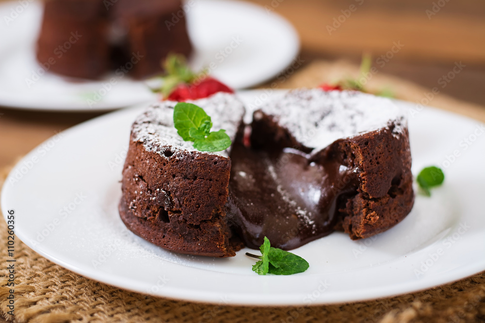 Chocolate fondant (cupcake) with strawberries and powdered sugar Chocolate fondant (cupcake) with strawberries and powdered sugar