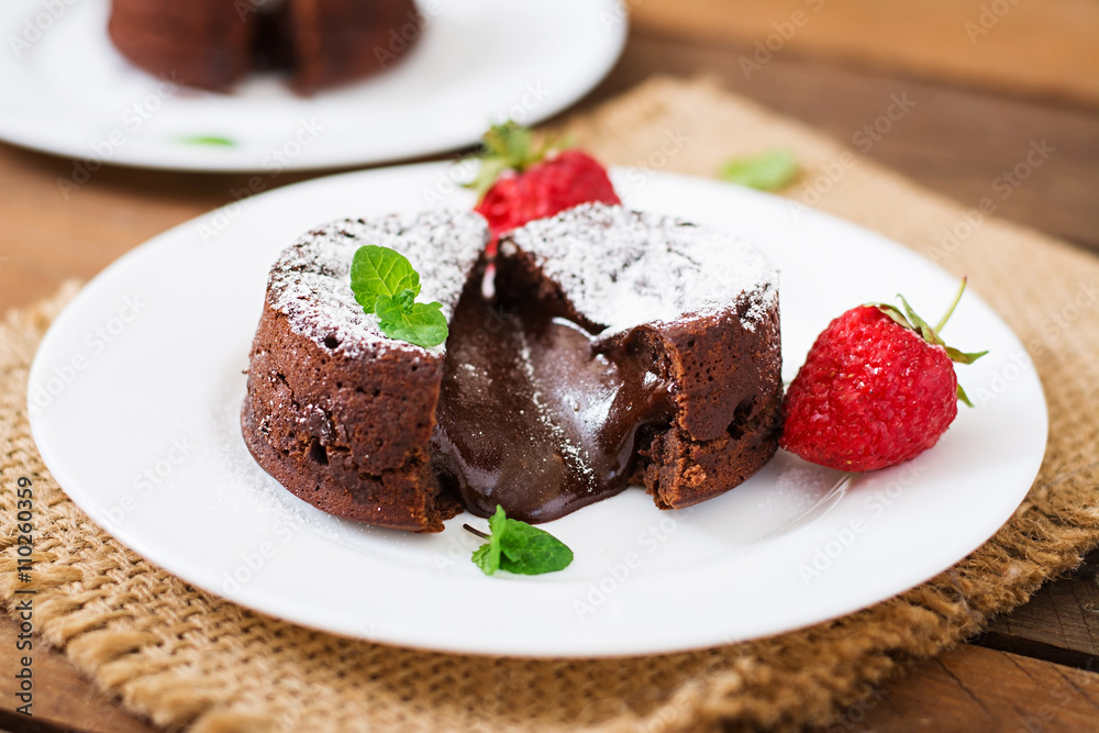 Chocolate fondant (cupcake) with strawberries and powdered sugar Chocolate fondant (cupcake) with strawberries and powdered sugar