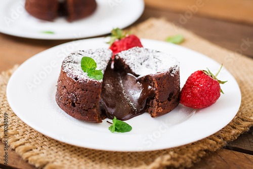 Konstfotografi Chocolate fondant (cupcake) with strawberries and powdered sugar