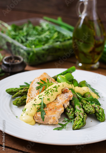 Baked chicken garnished with asparagus and herbs