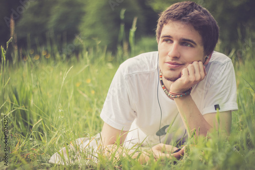 Junger Mann liegt im Gras, nachdenklich © Patrick Daxenbichler