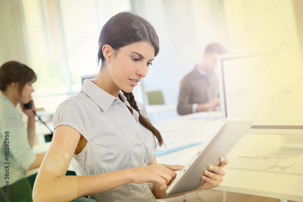 Young business girl working on digital tablet in office Young business girl working on digital tablet in office