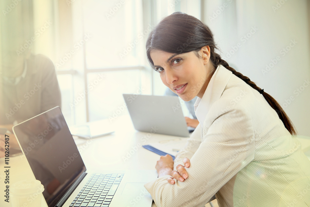 Businesswoman working on laptop, shared workspace Businesswoman working on laptop, shared workspace