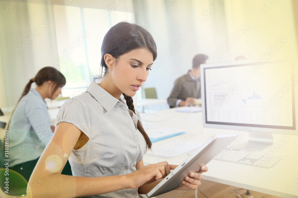 Young business girl working on digital tablet in office Young business girl working on digital tablet in office