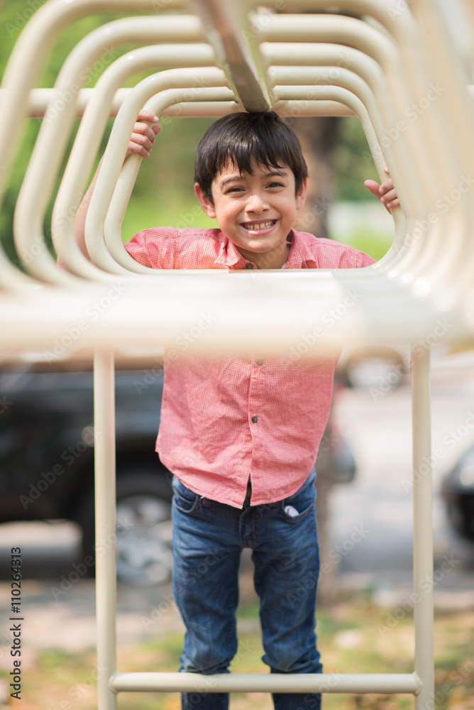 Fototapeta premium Little boy playing at playground climbing