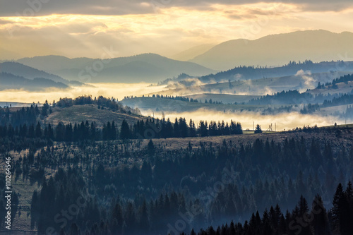 cold fog on hot sunrise in mountains