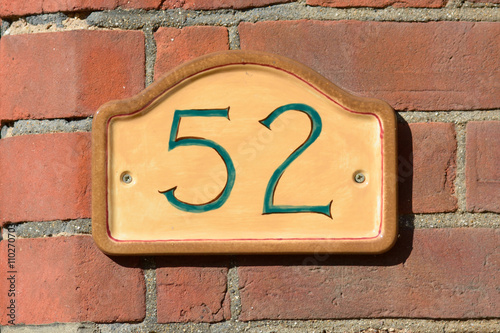 House Number 52 sign on wall
