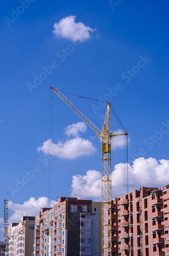 Construction of a brick high-rise building with a crane
