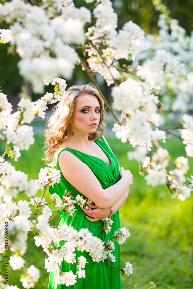Beautiful happy young woman in spring blossoming garden Beautiful happy young woman in spring blossoming garden