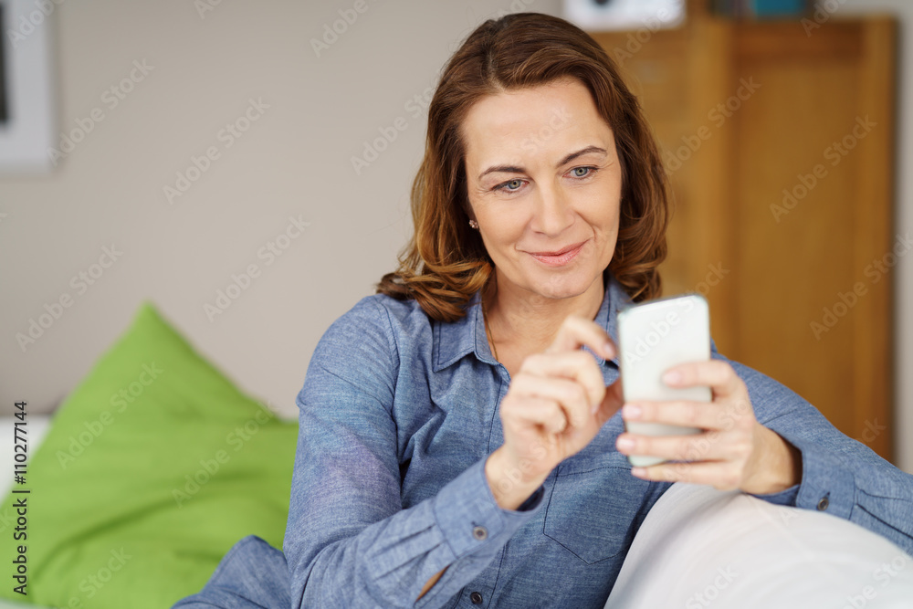 frau sitzt auf dem sofa und schreibt eine nachricht frau sitzt auf dem sofa und schreibt eine nachricht