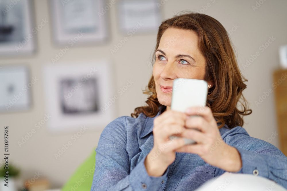 entspannte ältere frau sitzt auf dem sofa und hält ihr handy in den händen entspannte ältere frau sitzt auf dem sofa und hält ihr handy in den händen