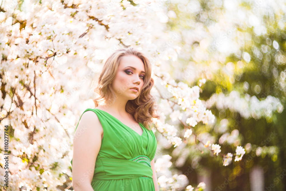 Beautiful happy young woman in spring blossoming garden Beautiful happy young woman in spring blossoming garden