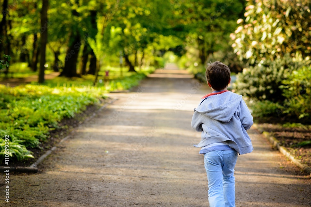 Little boy running in the park. Back view Little boy running in the park. Back view