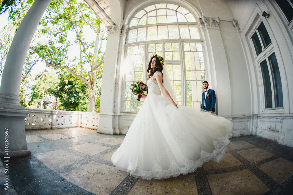 incredible bride in a beautiful dress posing in front of husband
