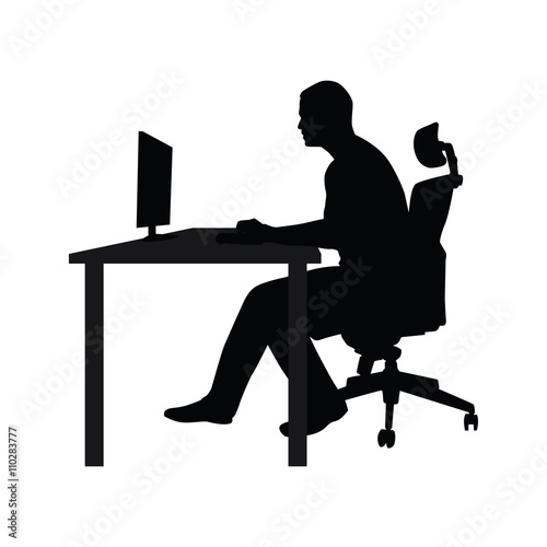 Man sitting on office chair at table and working on computer. Si