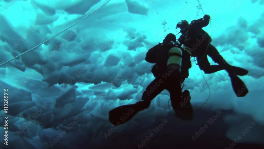 Unique extreme underwater shooting scuba dive beneath ice at geographic North Pole in cold waters. Fantastic views of the lump of ice in water. ICE CAMP BARNEO, NORTH POLE, ARCTIC - APRIL 10, 2015 Unique extreme underwater shooting scuba dive beneath ice at geographic North Pole in cold waters. Fantastic views of the lump of ice in water. ICE CAMP BARNEO, NORTH POLE, ARCTIC - APRIL 10, 2015