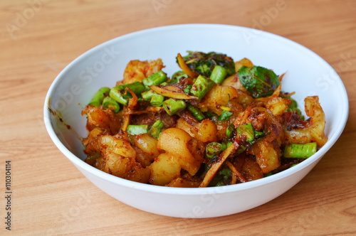 spicy stir fried pork tendon with herb on bowl