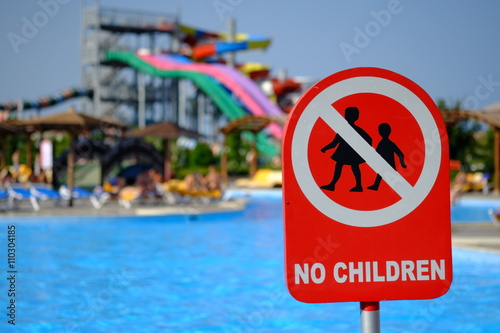 Red no children warning sign at the poolside