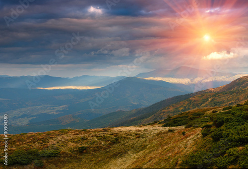 Panoramic landscape of mountain slopes at sunset.