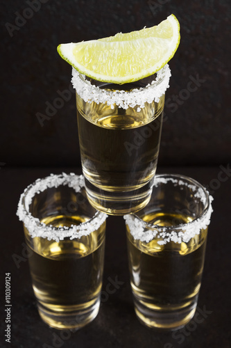 Tequila with salt and lime on a dark background