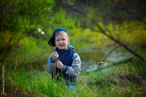 Cute boy  holding stick and  ready for eating roasted marshmallo photo