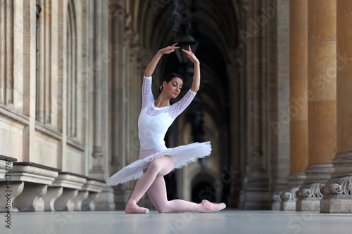 Beautiful ballerina in white tutu dancing in a palace photo