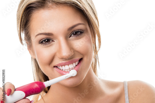 Smiling girl with electric toothbrush