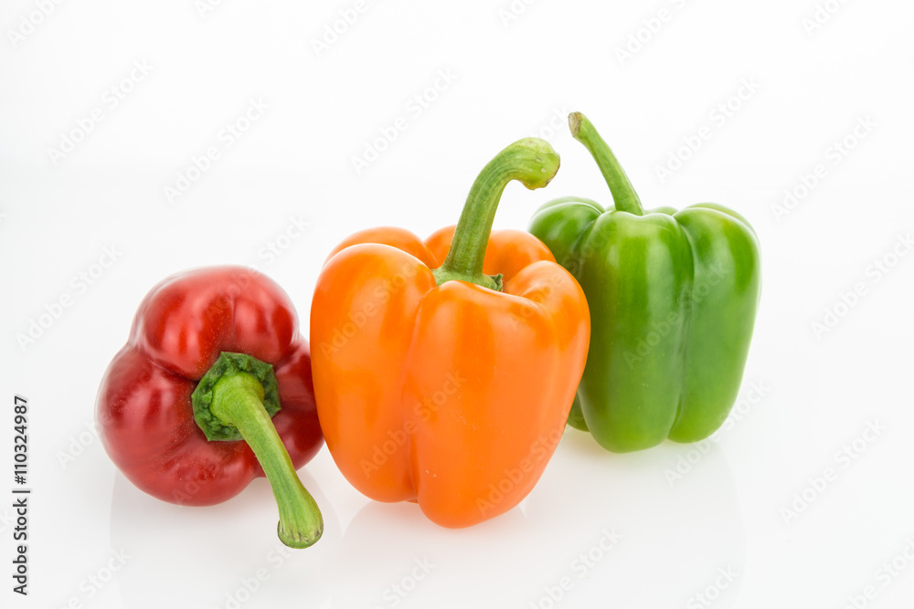 Fresh orange, green and red bell peppers, isolated on white background.