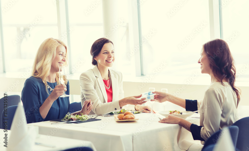 happy women giving birthday present at restaurant happy women giving birthday present at restaurant
