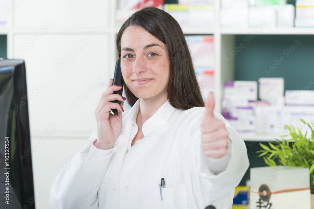 PTA in moderner Apotheke hält Daumen hoch PTA in moderner Apotheke hält Daumen hoch