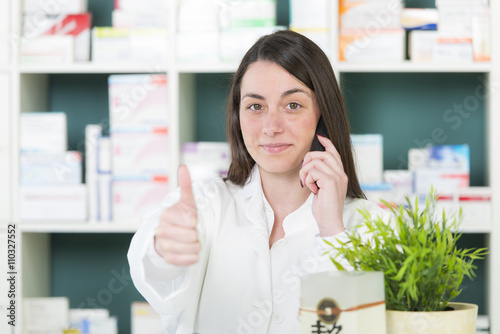 PTA in moderner Apotheke hält Daumen hoch photo