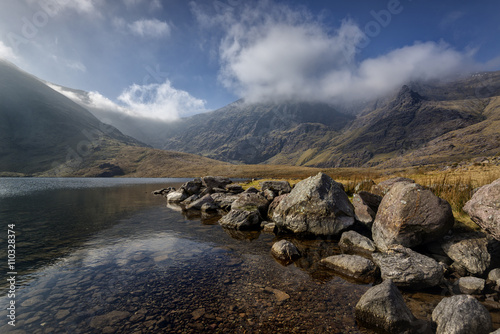 Carrauntoohil, the tallest peak in Ireland reflected in a calm lake, covered with clouds