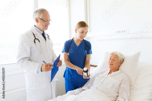 doctor giving medicine to senior woman at hospital