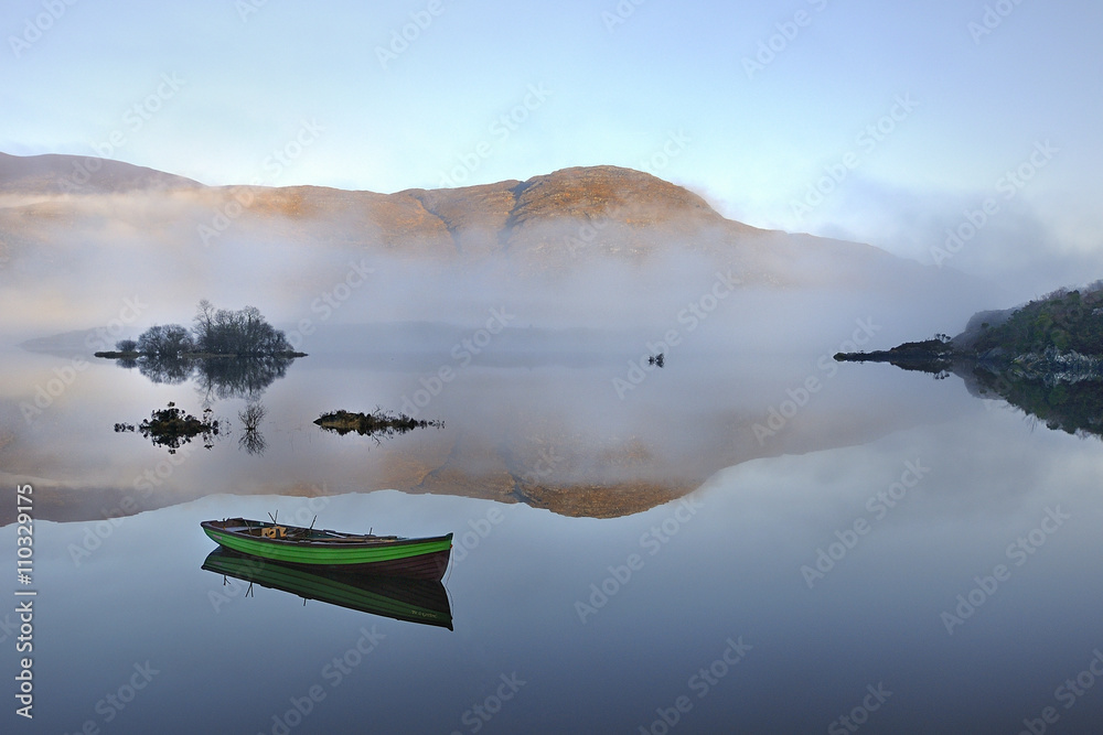 Fototapeta premium Boat at the Killarney lake in Co. Kerry, Ireland Foggy morning, Reflections