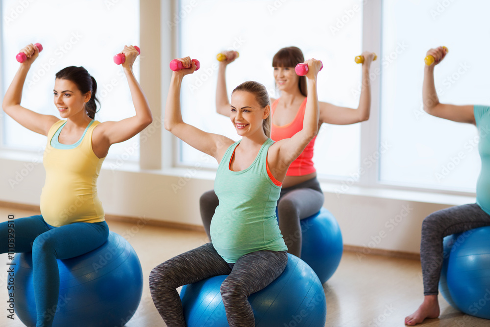 © Syda Productions - happy pregnant women exercising on fitball in gym