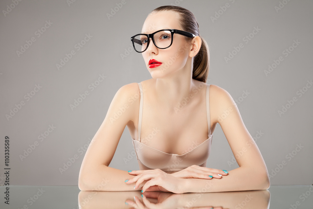 Portrait of young woman in glasses and bra looking away Stock